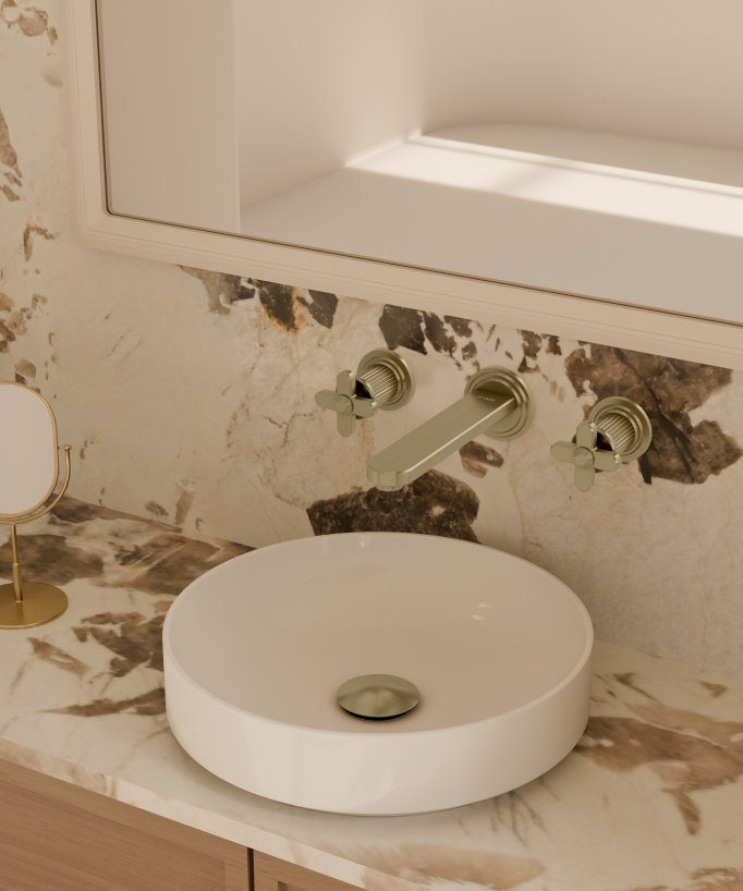 Mitigeur lavabo mural doré brossé, installé au-dessus d'une vasque à poser ronde blanche